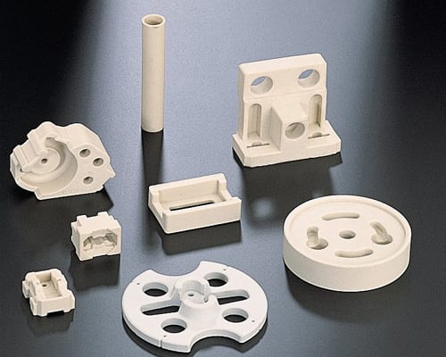 The image shows a group of white plastic parts sitting on top of a table. The parts appear to be part of a 3D printing process, as they are arranged in a neat and orderly fashion. The white color of t